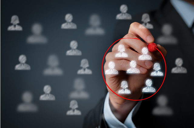 A person in a suit draws a red circle around a group of white human icons on a transparent screen, highlighting selected individuals among many blurred icons in the background.