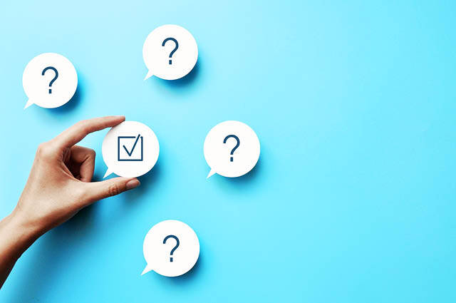 A hand selects a speech bubble with a checkmark among four other bubbles with question marks, all set against a blue background. A hand selects a speech bubble with a checkmark among four other bubbles with question marks, all set against a blue background.