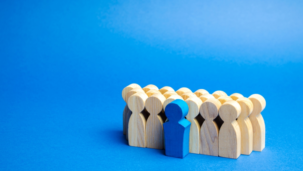 Wooden figurines standing in front of a blue background